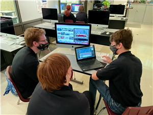 3 students work on computer ads